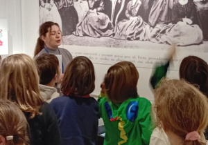 Uczniowie słuchają historii o rodzicach Marii Skłodowskiej-Curie.