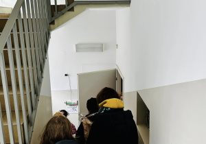Uczniowie schodzą po schodach do pomieszczeń, w których wykonuje się zdjęcia rentgenowskie, badania ultrasonograficzne oraz zabiegi i operacje..