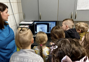 Dzieci oglądają na ekranie komputera wykonane zdjęcia rentgenowskie i próbują odgadnąć, która część ciała zwierzęcia została prześwietlona.