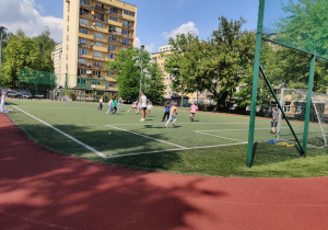 Uczniowie rozgrywają mecz na boisku.
