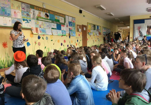 Nauczycielka zapowiada konkurs recytatorski.