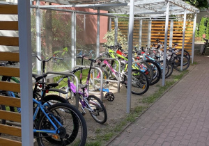 Rowery stoją pod wiatą rowerową i czekają na swoich właścicieli..