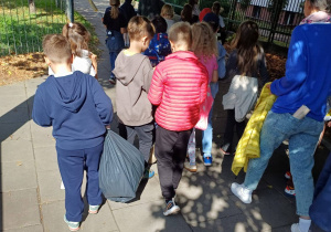 Uczniowie zmęczeni, ale szczęśliwi, z pełnymi workami, wracają do szkoły.