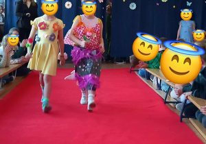 Dziewczynki prezentują swoje kolorowe kreacje na wybiegu.