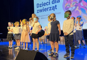 Uczniowie stoją na scenie podczas występu z okazji gali na zakończenie projektu.
