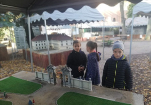 Uczniowie zwiedzają Park Miniatur i oglądają eksponaty.