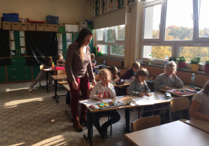 Wychowawca świetlicy klasy 2a sprawdza, jak dzieci radzą sobie wykonując zadania.
