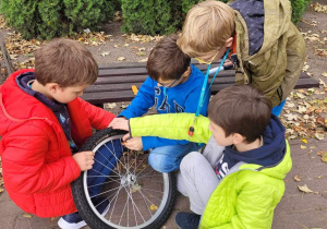 Michał, Rafał, Kacepr i Maksym zapoznają się z budową koła od roweru i sprawdzają, czy sprawdzają jest sprawne.