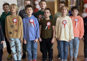 Uczniowie z kals 1-3 stoją na korytarzu i śpiewają hymn Polski.