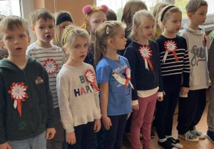 Uczniowie z kals 1-3 stoją na korytarzu i śpiewają hymn Polski.