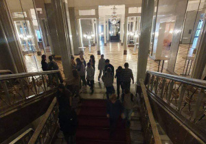 Uczniowie wchodza po schodach z czerwonym dywanem.