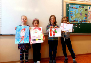 Laureaci konkursu plastycznego "Portret Świętego Mikołaja" prezentują swoje prace.