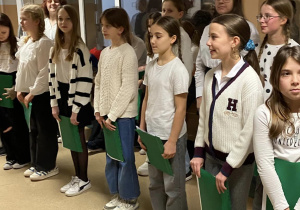 Szkolny chór "Srebrne głosy" stoi na łączniku i przygotowuje się do wejścia do sali gimnastycznej, gdzie odbywało się zebranie dla rodziców przyszłych pierwszoklasistów.