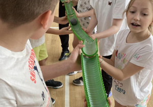 Uczniowie biorą udział w grze "Piłeczka w torze".