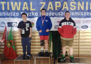 Adam stoi na podium podczas dekoracji medalami.