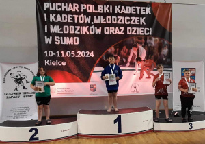 Karol stoi na podium podczas dekoracji medalami.