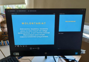 Na monitorze kompuetra wyświetla się początek prezenacji "Definicja wolontariatu".