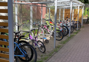 Rowery stoją pod wiatą rowerową i czekają na swoich właścicieli..