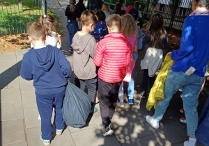 Uczniowie zmęczeni, ale szczęśliwi, z pełnymi workami, wracają do szkoły.