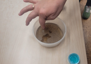 Pani pielęgniarka pokazuje dzieciom eksperyment.