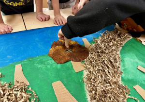 Po przyklejeniu pni drzew z tektury falistej (odzyskanej z opakowania prezentu), uczniowie przyklejają liście, jako korony drzew.