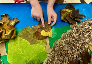 Uczniowie przyklejają liście, jako korony drzew.