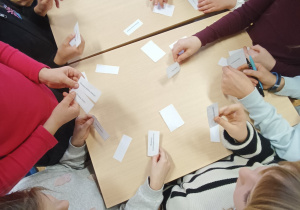 Uczniowie rozwiązują zadanie w klasie.
