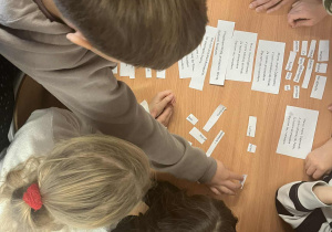 Uczniowie rozwiązują zadanie w klasie.