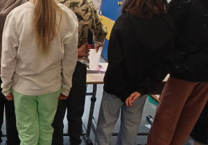 Uczniowie rozwiązują zadanie w klasie.