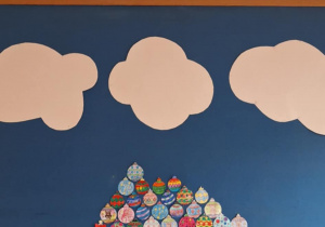 Na tablicy rośnie choinka wykonana przez uczniów, która prawie sięga do chmur.