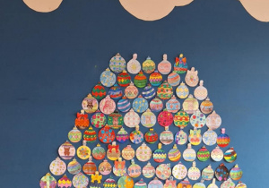 Na tablicy rośnie choinka wykonana przez uczniów, która prawie sięga do chmur.