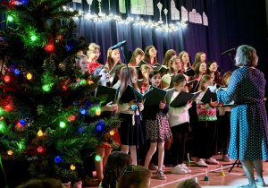 Chór, pod czujnym okiem Pani Olgi, śpiewa kolędę.