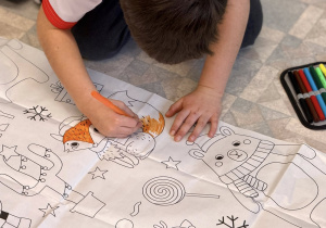 Chłopiec koloruje postać lisa.