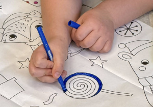 Dziewczynka koloruje lizaka.