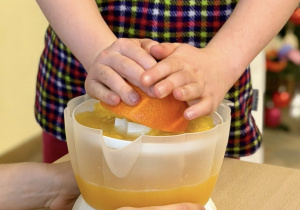 Uczennica wyciska sok z pomarańczy.