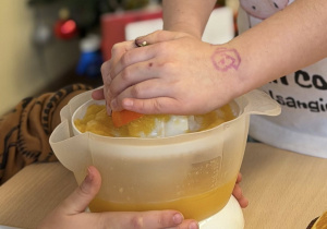 Uczeń wyciska sok z pomarańczy.