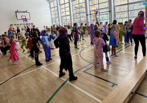 Uczniowie naśladując panią animator tańczą układ taneczny.