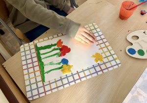 Chłopiec przykleja rolkę papieru do pracy.