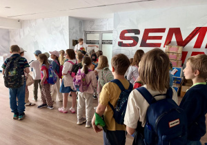 Dzieci stoją przy wejściu do szatni zawodników.