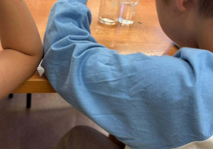Na zdjęciu widać chłopca, który bierze udział w zajęciach laboratoryjnych.